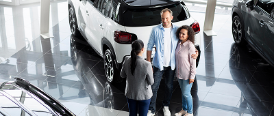 couple-searching-new-car-dealership 1